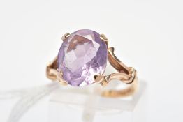 A 9CT GOLD AMETHYST RING, the oval amethyst within a four claw setting to the bifurcated