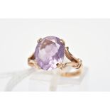 A 9CT GOLD AMETHYST RING, the oval amethyst within a four claw setting to the bifurcated