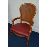 A REPRODUCTION HARDWOOD BERGERE BACK ARMCHAIR with burgundy leather seat