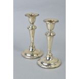 A NEAR PAIR OF EDWARDIAN SILVER CANDLESTICKS, concentric band decoration to rims, inverted conical