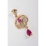 A 9CT GOLD RUBY PENDANT, of open work scrolling design set with a central oval cut ruby suspending a
