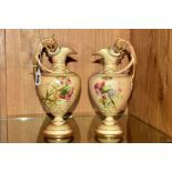 A PAIR OF ROYAL WORCESTER BLUSH IVORY EWERS, florally decorated with gilt detailing, the body raised