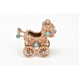 A 9CT GOLD CHARM, designed as a vintage pram set with turquoise stones, with rotating wheels, with