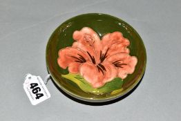 A SMALL MOORCROFT POTTERY FOOTED BOWL, 'Hibiscus' pattern, on green ground, impressed marks to base,