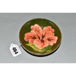 A SMALL MOORCROFT POTTERY FOOTED BOWL, 'Hibiscus' pattern, on green ground, impressed marks to base,