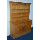 A MODERN PINE DRESSER with a three tier plate rack and three drawers, width 138cm x depth 43cm x