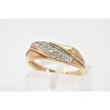 A 9CT GOLD RING, designed as a diagonal line of three single cut diamonds in pave settings to the