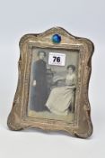 AN EARLY 20TH CENTURY SILVER FRONTED PHOTO FRAME, with embossed floral and foliate detail and a