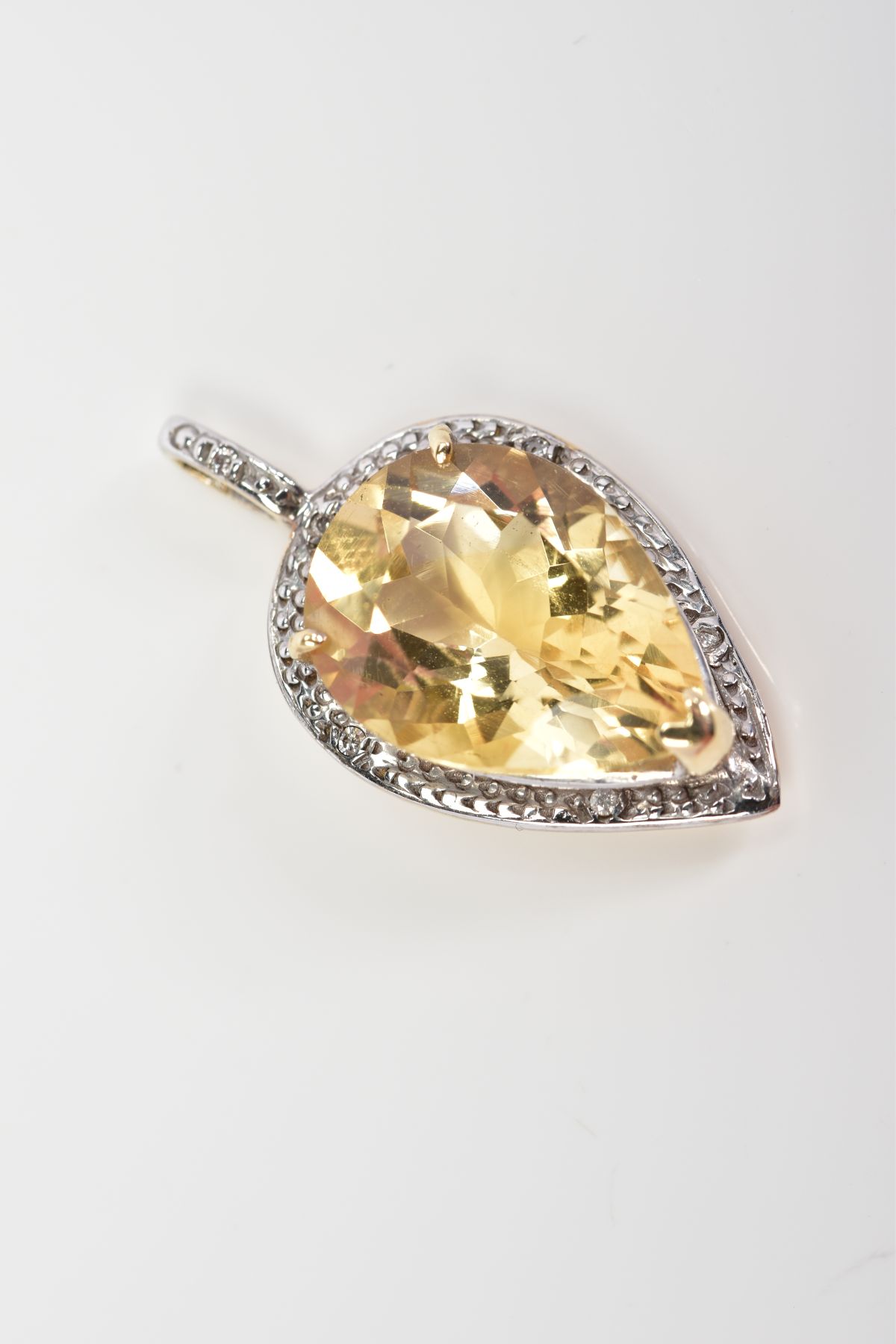 A 9CT GOLD PENDANT, designed with a pear cut citrine within a raised three claw setting and