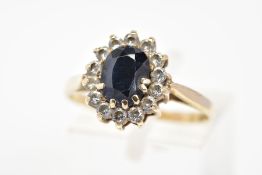 A 9CT GOLD SAPPHIRE AND CUBIC ZIRCONIA CLUSTER RING, set with a central oval cut sapphire and