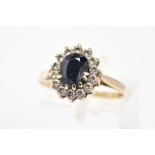 A 9CT GOLD SAPPHIRE AND CUBIC ZIRCONIA CLUSTER RING, set with a central oval cut sapphire and