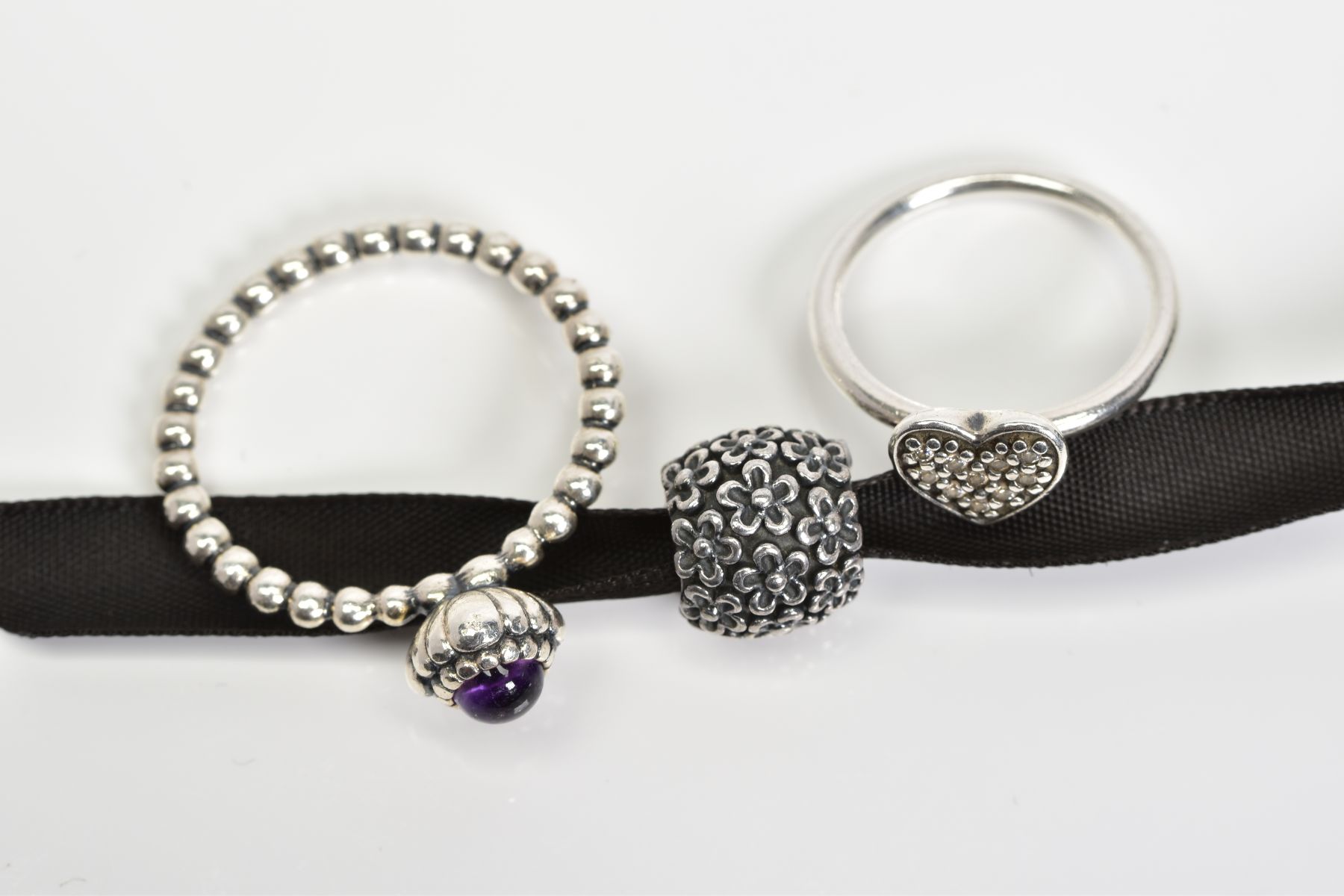 TWO PANDORA RINGS AND A CHARM, the first ring designed with a central amethyst to the beaded band, - Image 2 of 3