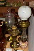 FOUR OIL LAMPS, comprising three brass based oil lamps, two with chimneys and shades and a small