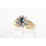 A 9CT GOLD SAPPHIRE AND DIAMOND CLUSTER RING, the central oval sapphire within a surround of eight