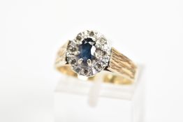 A 9CT GOLD SAPPHIRE AND DIAMOND CLUSTER RING, the central oval sapphire within a surround of eight