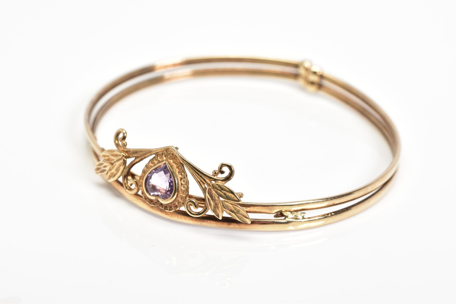 AN AMETHYST BANGLE, designed with a heart shape amethyst in a collet setting within a foliate - Image 2 of 4