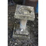 A COMPOSITE TWO PIECE BIRD BATH with a two tier stepped base, a square stem with detailed edges