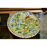 A 19TH CENTURY MAIOLICA CHARGER, painted with a border of blue and yellow dots, the centre with a