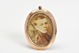 AN EARLY 20TH CENTURY ROLLED GOLD PHOTOGRAPH PENDANT, of oval outline with photograph panels to