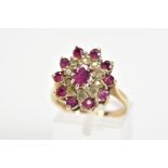 A 9CT GOLD GARNET AND DIAMOND CLUSTER RING, designed as a central oval garnet within a single cut