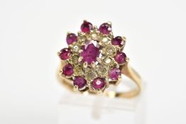 A 9CT GOLD GARNET AND DIAMOND CLUSTER RING, designed as a central oval garnet within a single cut