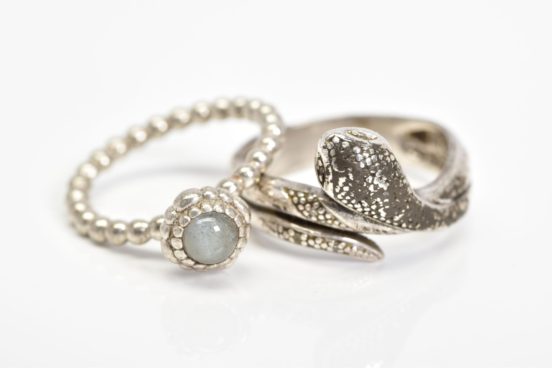 A PANDORA RING AND A SNAKE RING, the Pandora ring designed with a circular rock crystal cabochon