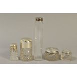 FOUR EARLY 20TH CENTURY SILVER TOPPED GLASS TOILET JARS, two cylindrical and two circular, including