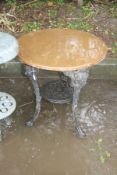 A CAST IRON PUB TABLE with a black painted base, female face mask detail to the tops of all three