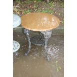 A CAST IRON PUB TABLE with a black painted base, female face mask detail to the tops of all three