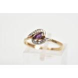A 9CT GOLD AMETHYST AND DIAMOND DRESS RING, the central oval amethyst set on a diagonal within a