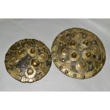 TWO INDIAN/PERSIAN LEATHER AND BRASS MOUNTED SHIELDS, losses to the front of the smaller shield,