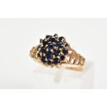 A 9CT GOLD SAPPHIRE CLUSTER RING, designed as a tiered cluster of claw set circular sapphires to the