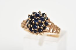 A 9CT GOLD SAPPHIRE CLUSTER RING, designed as a tiered cluster of claw set circular sapphires to the