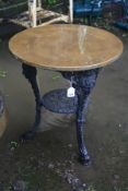 A CAST IRON PUB TABLE with a black painted base, female face mask detail to the tops of all three