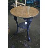 A CAST IRON PUB TABLE with a black painted base, female face mask detail to the tops of all three