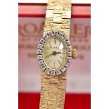 A LADIES 9CT GOLD BUECHE GIROD DIAMOND WRISTWATCH, the oval face with black hands and baton markers,
