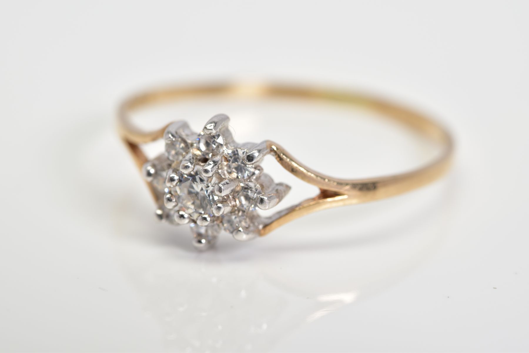 A 9CT GOLD CUBIC ZIRCONIA CLUSTER RING, designed as a cluster of circular colourless cubic