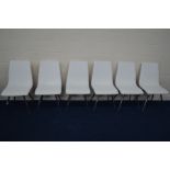 A SET OF WHITE LEATHERETTE DINING CHAIRS on chrome bases