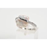 A 9CT WHITE GOLD RING, designed as a square mother of pearl centre with a vertical crossover bar set