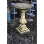 A COMPOSITE TWO PIECE BIRD BATH with a stepped and detailed base, square baluster tapering stem