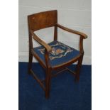 AN EARLY TO MID 20TH CENTURY OAK BAR ARMCHAIR, with needlework drop in seat pad, stamped Heals,