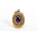 A VICTORIAN MEMORIAL LOCKET, of oval design set with a central oval garnet with engraved surround,