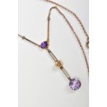 AN EDWARDIAN AMETHYST AND DIAMOND DROP PENDANT NECKLACE, designed with an oval cut amethyst