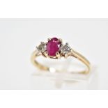 A 9CT GOLD RUBY AND DIAMOND RING, the central oval glass filled ruby flanked by brilliant cut