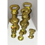 A SET OF EIGHT BELL SHAPED BRASS WEIGHTS, including Victorian examples, stamped weights mostly worn,