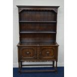 AN EARLY TO MID 20TH CENTURY OAK DRESSER, with two plate rack shelves, above cupboard geometric