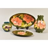 FOUR ITEMS OF MOORCROFT, to include an oval trinket dish, length 23cm, Hibiscus pattern on a green