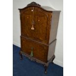 A REPRODUCTION BURR WALNUT TWO DOOR DRINKS CABINET, beech lined interior with a brushing slide and