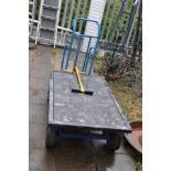 A FOUR WHEELED FLAT BED TROLLEY, metal framed with plywood bed, length 145cm x width 76cm x height