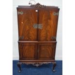 A BRIDGECRAFT MAHOGANY TWO DOOR COCKTAIL CABINET, with an illuminated mirrored interior, brushing